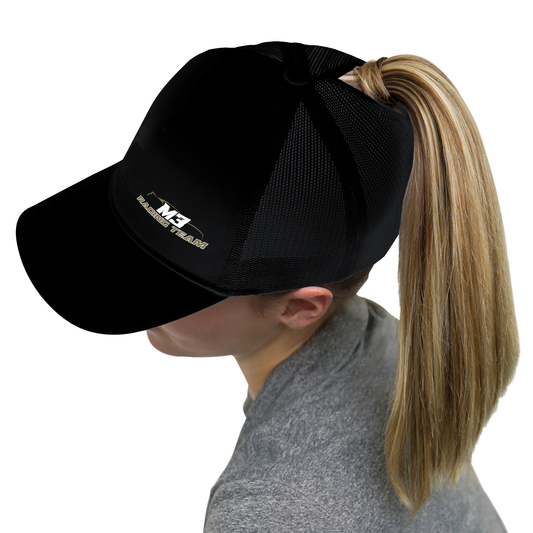 Femme portant une casquette noire avec trou arrière pour une queue-de-cheval.
